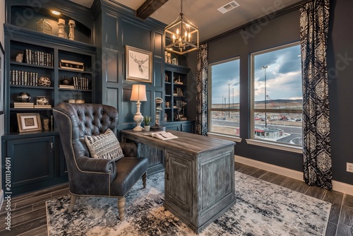 Home office features a rich dark blue paneled wall, a stately leather chair, and a large wooden desk positioned near a window that overlooks a quiet suburban street during the late afternoon sunlight.