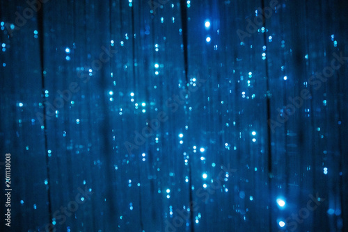 Dark blue abstract virtual background with a dense network of shimmering, light-emitting strands resembling fiber optics or stars.