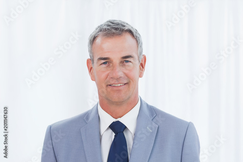 Quadro su tela Middle-aged man posing for corporate headshot in studio wearing light gray suit