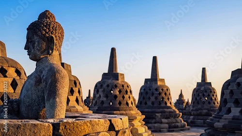 Ancient stone Buddha statue at Borobudur temple complex at sunrise
