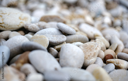 Close up macro photograph capturing smooth natural beach stones with soft background blur