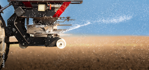 Photography Tractor spreading artificial fertilizers in field
