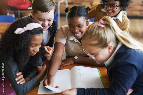 Canvastavla Students, smile and children with note in classroom, development and reading secret and information