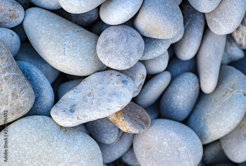 Fotografie Close up arrangement of naturally rounded light grey beach stones and pebbles