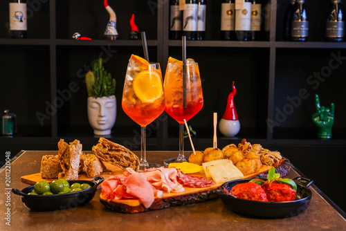 Fotografie Aperitivo servito in un bar con spritz, tagliere di salmi e formaggi, polpette a