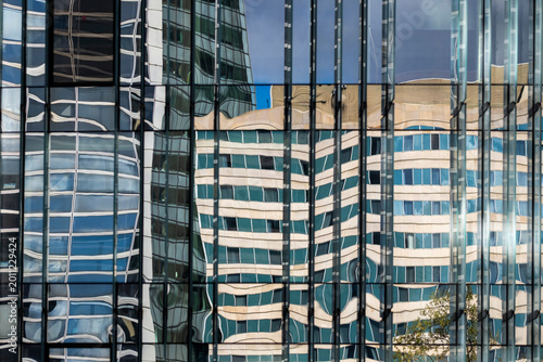 Abstract corporate reflections with subtle distortion on modern glass facade turn the building architecture pattern into fluid visual rhythm