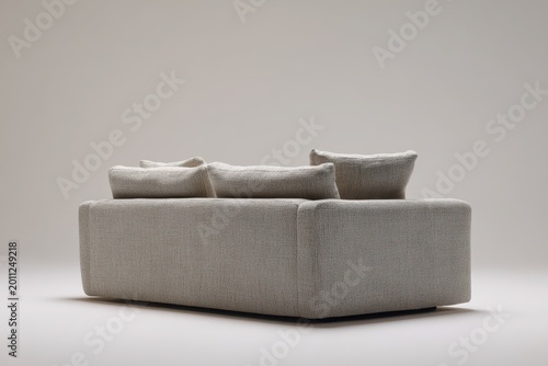 Back view of a contemporary gray couch in a neutral living room backdrop