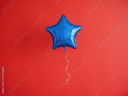 Blue star balloon on vibrant red background for celebrations and parties