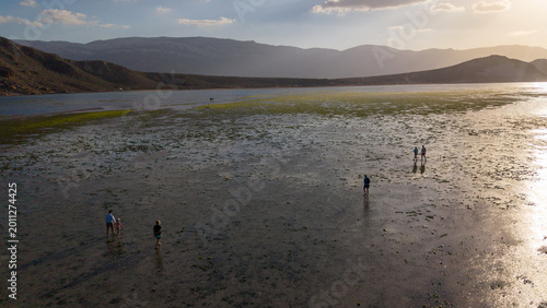 Schilderij op canvas Aerial sunset over tidal flats with walkers and distant mountains
