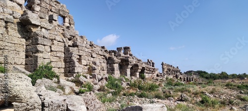 Photos Crumbling stone walls with arched windows in a grassy field illustrating Historical archaeological sites
