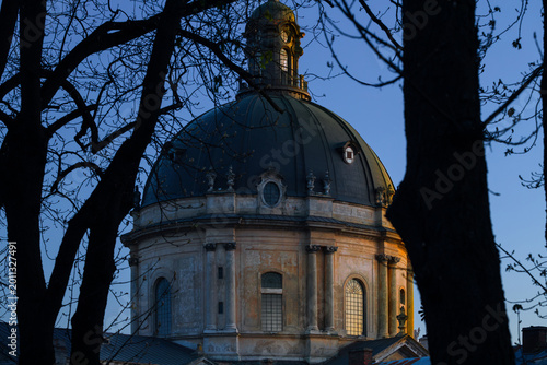 Obraz na płótnie aged cathedral dome in twilight low key view with bare branches of autumn depres