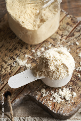 Whey protein powder in a scoop and jar