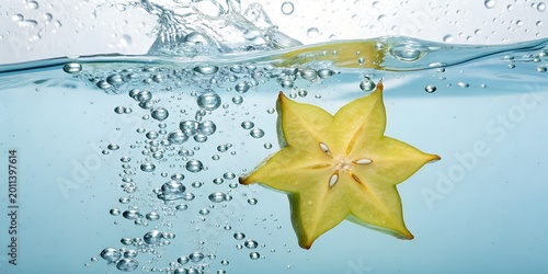 star fruit splashing into clear water with many bubbles.