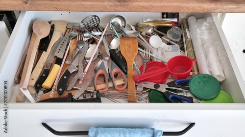 Bild auf Leinwand Messy kitchen drawer with disorganized cutlery and utensils
