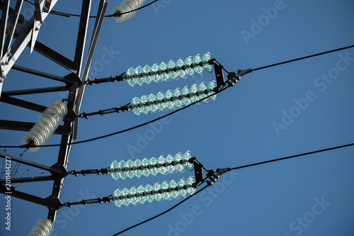 Tableau sur toile Close-up of electrical power transmission lines and insulators against a clear b