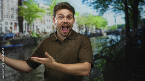 Man with open hands and open mouth gesturing on a canal street in amsterdam near bicycles and canal boats; joy travel discovery.