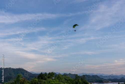 Paraglider Soaring Over Lush Mountains and Lake