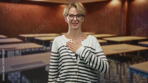 Billede på lærred Woman hand on chest and right hand raised palm out as pledge inside building; sincerity commitment respect
