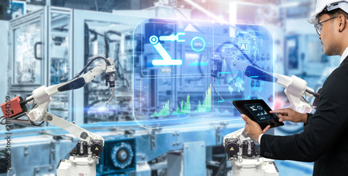 Smart technology industry control concept.Hands holding tablet on blurred automation machine as background