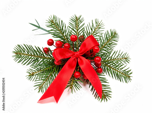 Festive greenery adorned with bright red berries and ribbon bow. Fresh pine branches with vibrant red fruit. Red bow ties elegant holiday arrangement. White background enhances festive colors