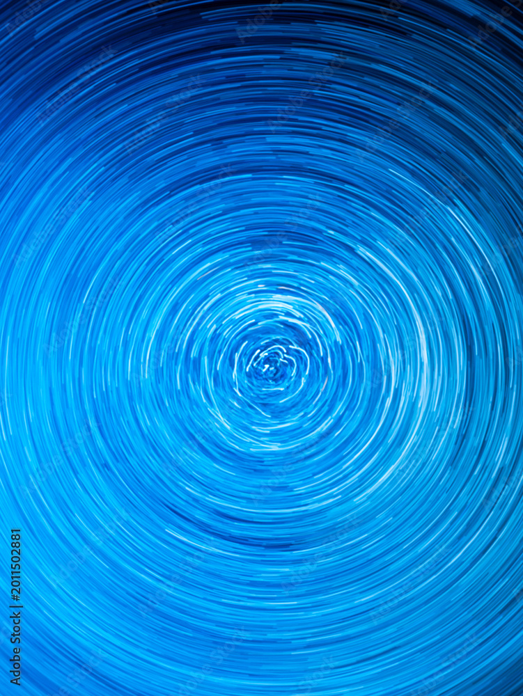 Fototapeta premium Abstract blue spiral light trails and circular long exposure motion effect with futuristic cosmic energy background