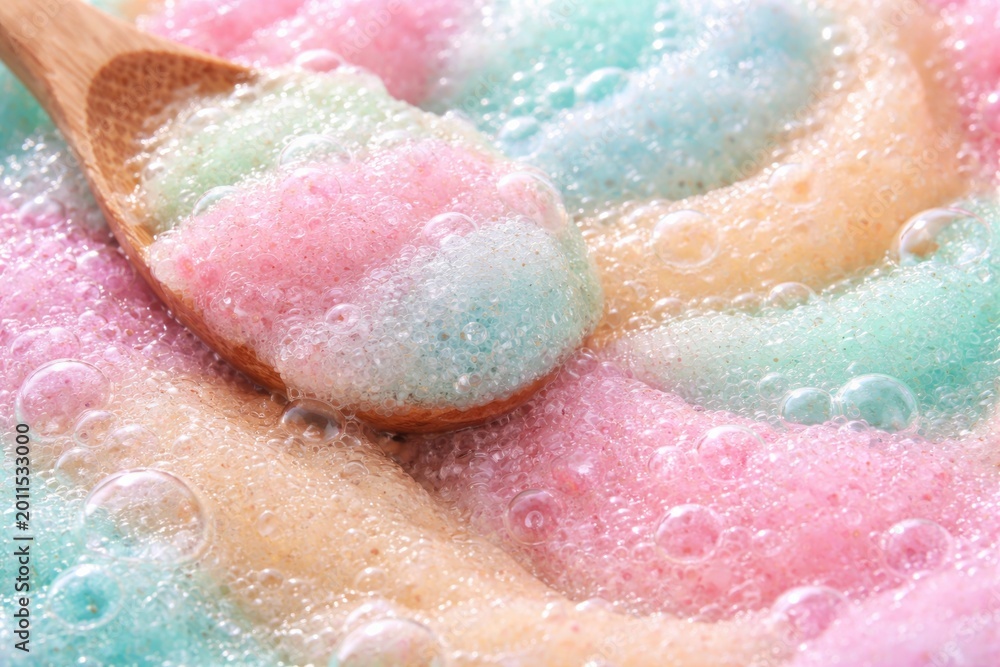 Fototapeta premium Pastel palette exfoliating body scrub close up showing bubble texture ideal for skin care rituals