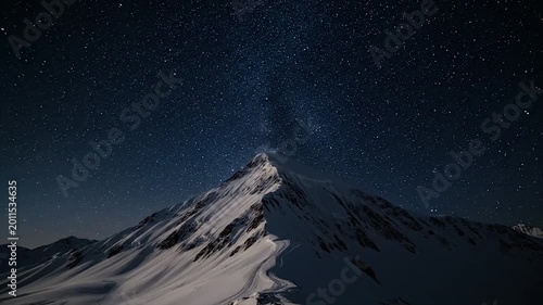 Snow-covered mountain peak under a starry night sky