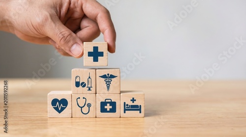 A person's hand stacking blocks with medical icons