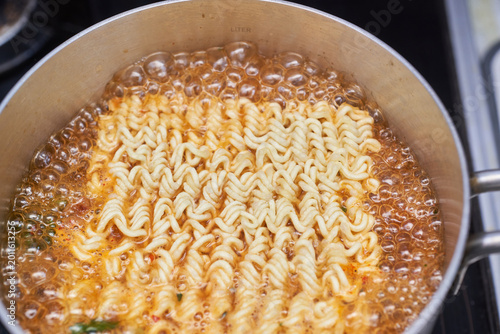 Photography This dynamic close up captures traditional Korean spicy ramen boiling vigorously in a stainless steel pot