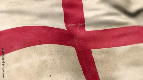A England flag, made of old cloth, dirty and stained, flutters in the wind. A Worn England Flag Waves In The Breeze.