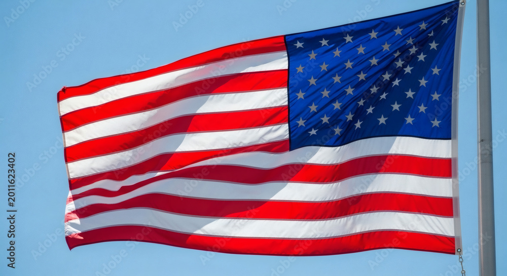 Fototapeta premium American flag waving against a clear blue sky