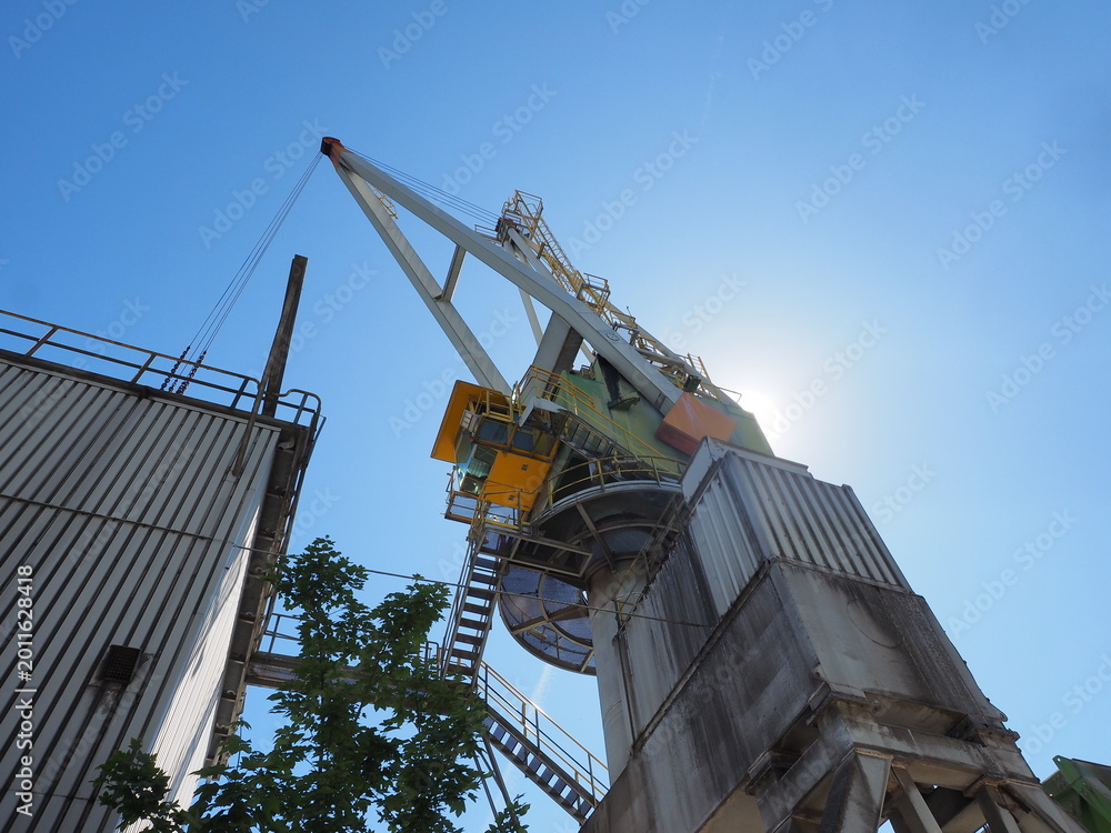 Fototapeta premium Industrial Crane at ENCI Site in Maastricht Against Clear Blue Sky