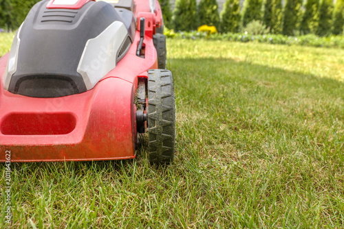 Lawn mower on a green meadow. Gardening equipment