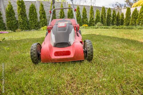 Lawn mower on a green meadow. Gardening equipment