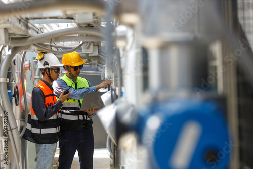 Konstfotografi engineers inspecting industrial hvac system on rooftop