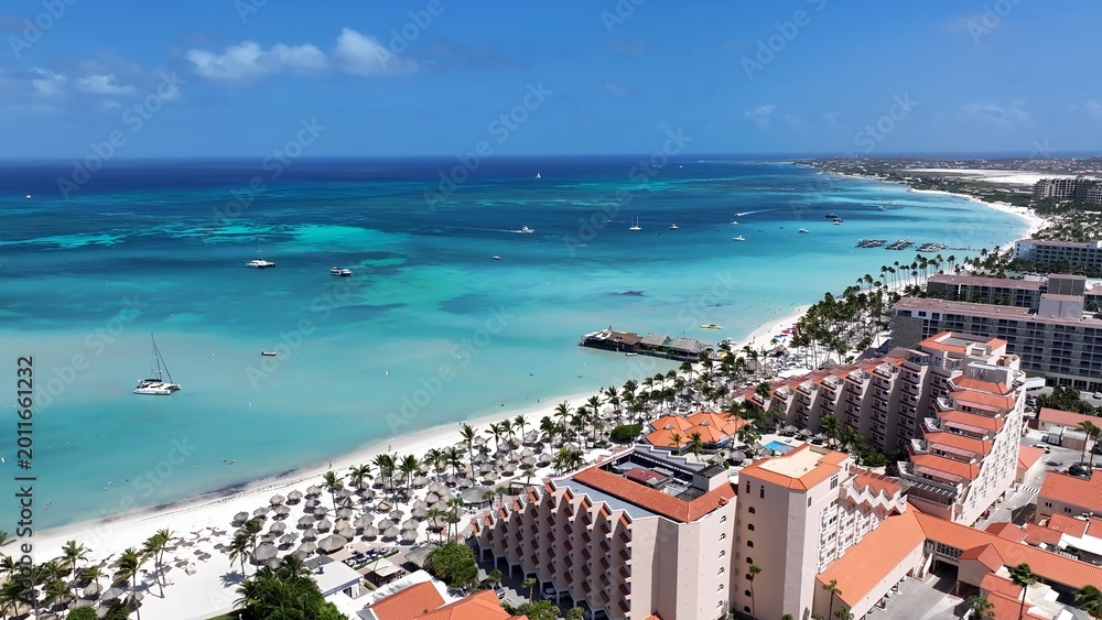 Fototapeta premium Palm Beach In Noord Oranjestad Aruba. Stunning Tropical Coastline Beach Scene Viewed From Above. Paradise Skyline Grateful Vibrant. Paradise Sea. Noord Oranjestad.