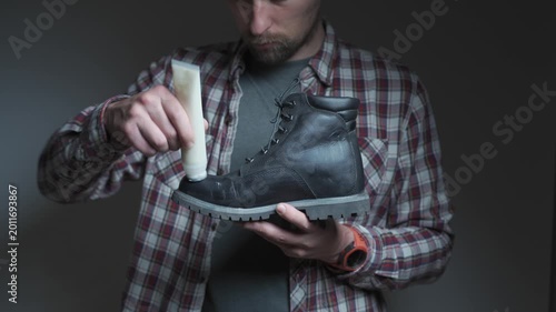 Shoe care in action as cream is applied to a black leather boot. The scene highlights cleaning, conditioning and restoring footwear quality.