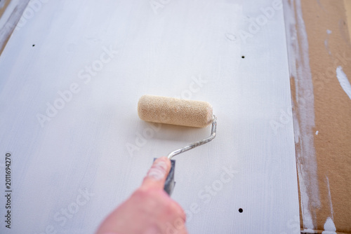 Foto Carefully applying white primer on drywall with visible imperfections and soft n