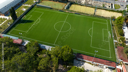 Foto Aerial perspective of a lush green football pitch with white markings, situated within a sports facility