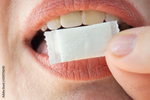 Quadro su tela nicotine pouch snus white small bag person putting tobacco product in mouth clos