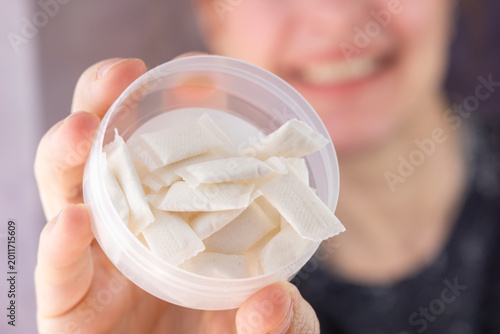 Tableau sur toile person holding open container of white nicotine pouches or snus portions close u