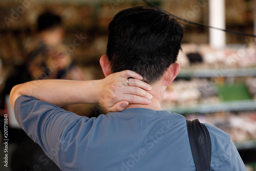 Man walking exploring outdoor market in hot weather in Bangkok, male hand skin, unposed movement, natural candid motion, rear view.