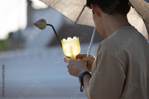 Foto Male believer walking in candlelight procession around Buddha statue on Makha Bucha Day at Phutthamonthon, close up