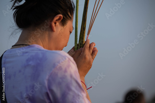 Foto Thai female believer walking in candlelight procession around Buddha statue on Makha Bucha Day, close up, at Phutthamonthon
