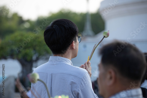 Tableau sur toile Thai male believer walking in candlelight procession around Buddha statue on Makha Bucha Day at Phutthamonthon, close up