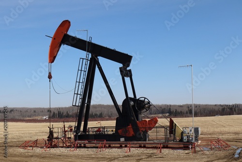 Quadro su tela A pumpjack, or nodding donkey on a crude oil well pumping oil into a pipeline