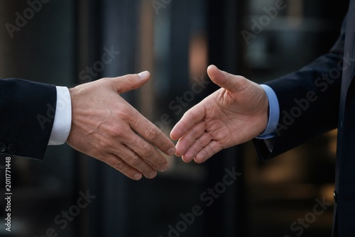 Close Up of two corporate businessmen shaking hands in agreement
