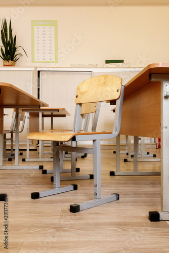 Photos Empty wooden chair and desks in school classroom interior