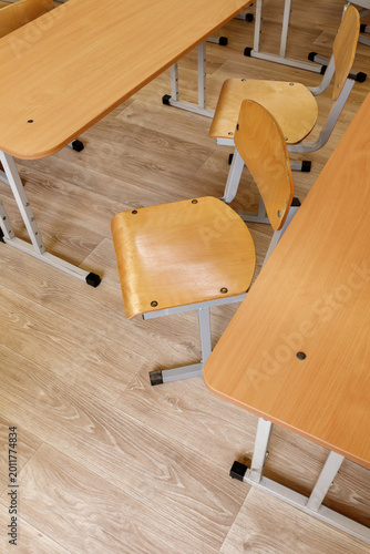 Tableau sur toile Empty wooden chair and desks in school classroom interior