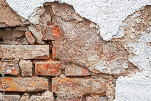 Canvastavla Old brick wall with peeling plaster and rough texture showing age in a building